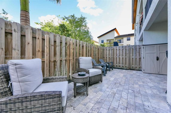 Outdoor patio area with seating and fenced enclosure.