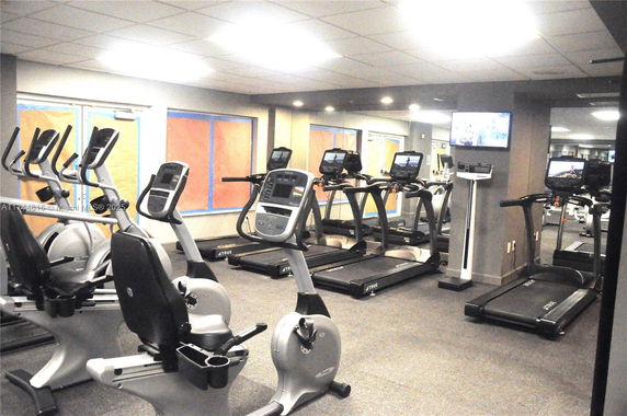 Interior view of a gym with treadmills and exercise bikes.