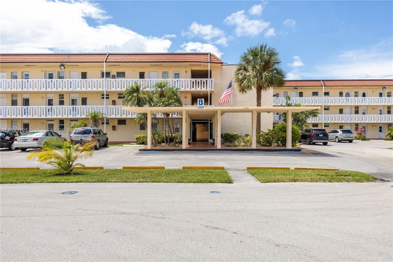 Front view of a multi-story apartment building with balconies.