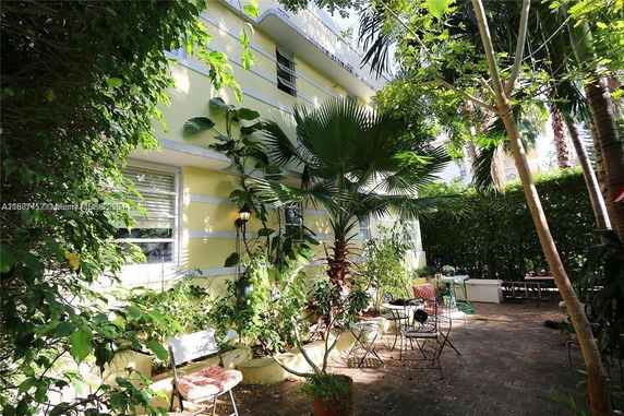 View of surrounding greenery and patio area beside a two-story building.
