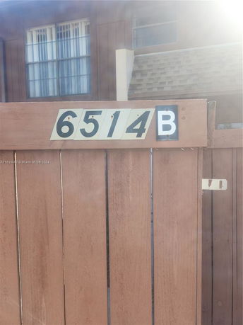 Front view of a building with wooden fence and address number 6514B.