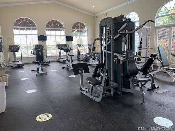 Indoor gym area with various exercise equipment and large windows.