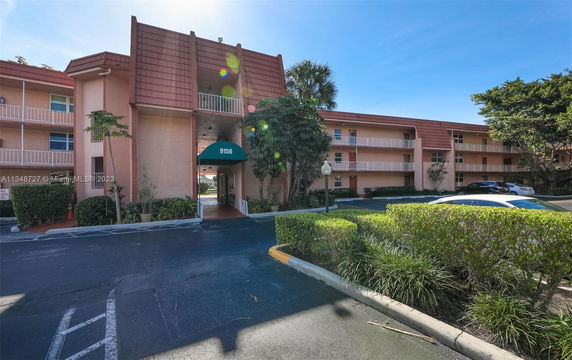 Front view of a multi-story building with balconies and a canopy entrance.