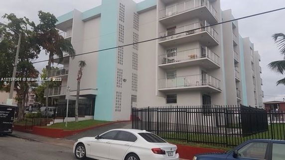 Front view of a multi-story apartment building with balconies.