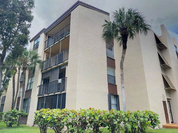 Front view of a four-story apartment building with balconies.