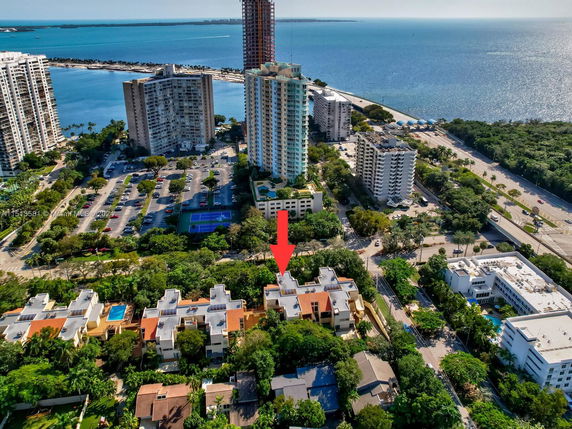 Panoramic aerial view of a coastal city with high-rise buildings and waterfront.