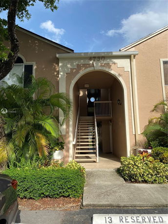 Front view of a two-story building with stairs leading up to the entrance.