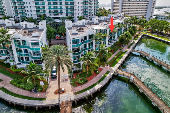 Aerial view of a waterfront apartment complex with multiple buildings and a promenade.
