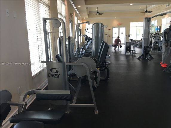 Indoor fitness area with gym equipment and exercise machines.