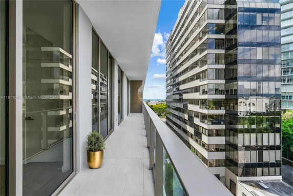 Balcony view from a high-rise building, showing adjacent modern glass office buildings.