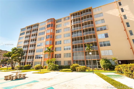 Front view of a multi-story apartment building with balconies.