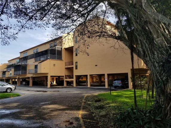 Front view of a multi-story residential building with parking area underneath.