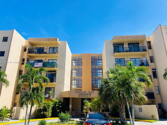 Front view of a multi-story condominium building with balconies.