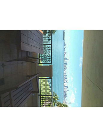 Panoramic view from a balcony overlooking a large body of water and a distant city skyline.