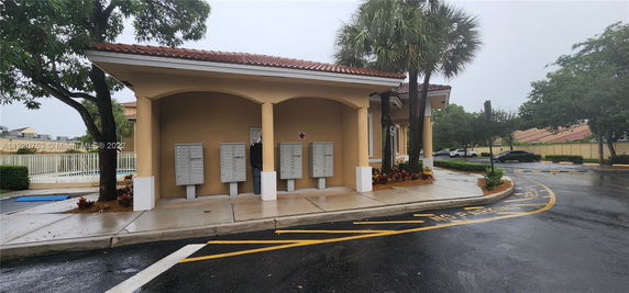 Front view of a small structure with mailboxes and a tiled roof.