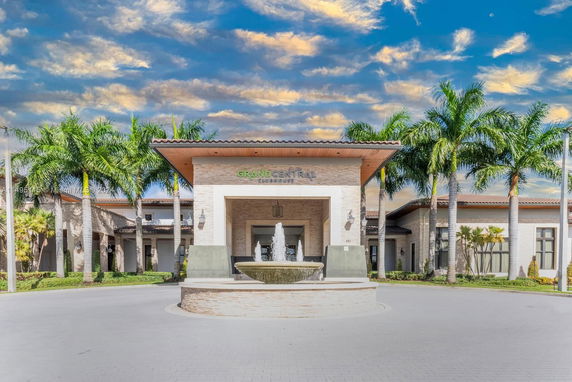 Front view of the Grand Central Clubhouse with palm trees and a fountain.