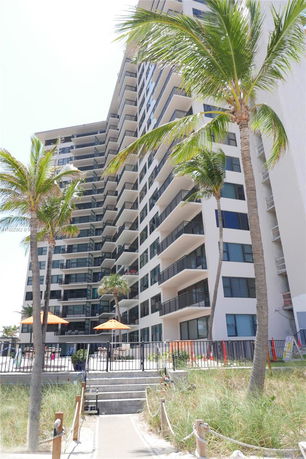 Front view of a high-rise residential building with multiple balconies.