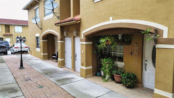 Front view of a multi-story building with arched entrances and tan exterior.