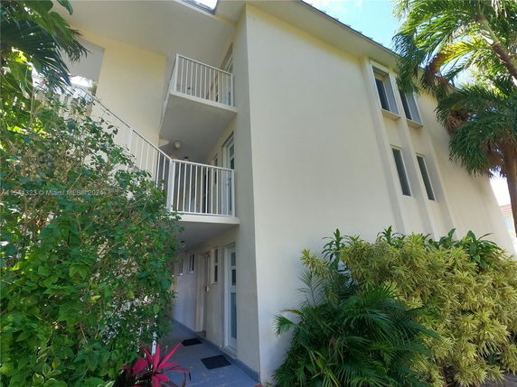 View of a multi-story building with balconies and outdoor stairs.