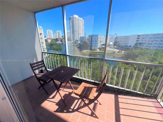 Balcony view showcasing nearby high-rise buildings and a waterway.