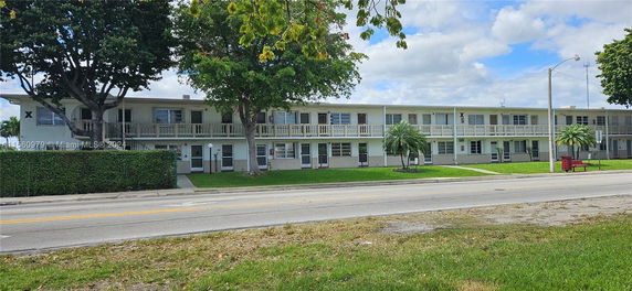 Front view of a two-story apartment building with balconies.