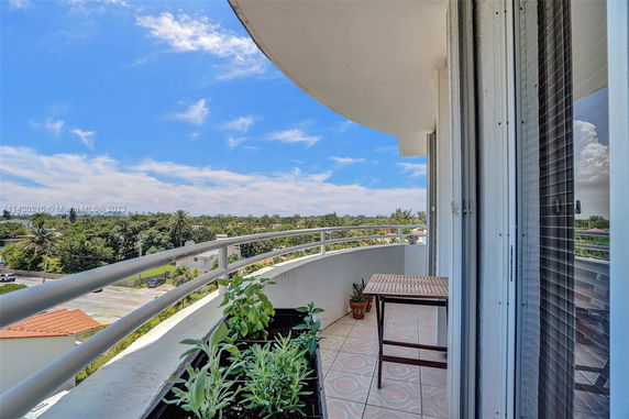 Balcony view with plants and outdoor furniture overlooking a scenic landscape.