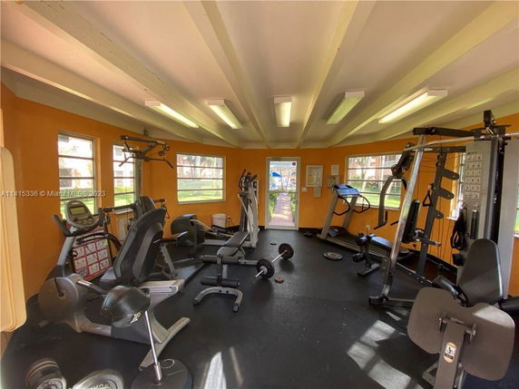 Indoor gym area with various exercise equipment including treadmills, weights, and machines.