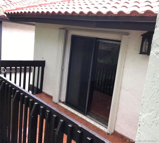 Terracotta tiled rooftop and balcony with sliding glass door.
