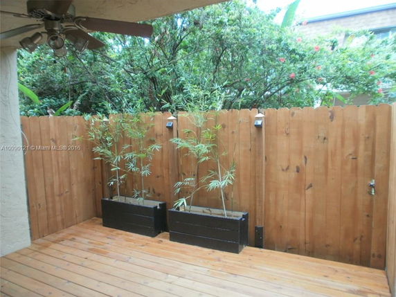 Wooden deck with planters and a wooden fence.