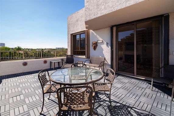 Rooftop patio with outdoor furniture and a view of surrounding areas.