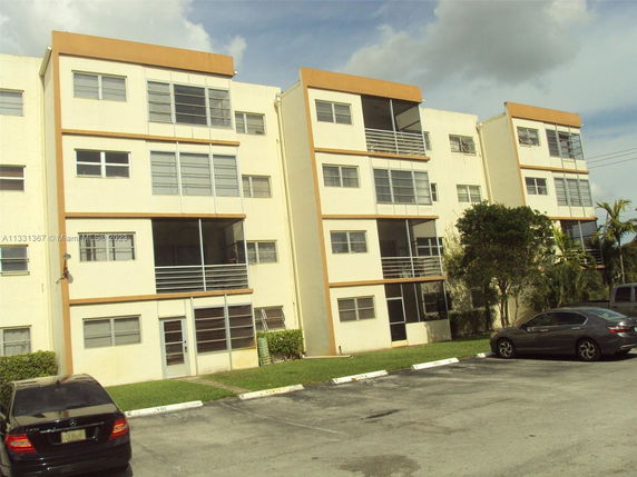 Front view of a multi-story apartment building with balconies.