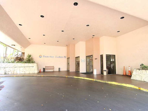 Front view of a building entrance with a covered driveway.