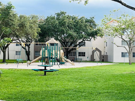 Playground with swings and slides in a residential area.