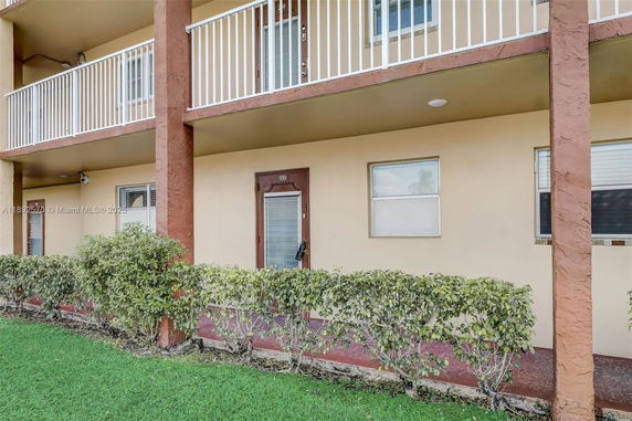Front view of a multi-story building with balconies and numbered doors.