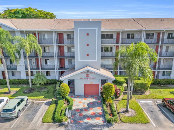 Front view of a multi-story residential building with balconies and ground-level entrance.