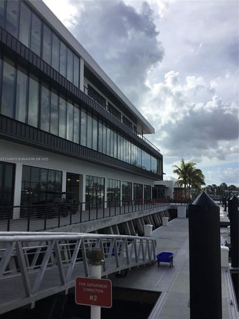Side view of a building near a dock with a modern glass facade.