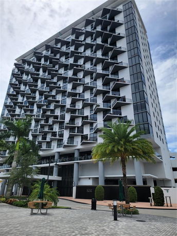 Front view of a multi-story building with a modern facade and balconies.