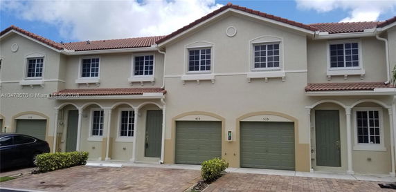 Front view of a two-story townhouse with individual garages.