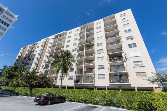 Front view of a multi-story apartment building with balconies.
