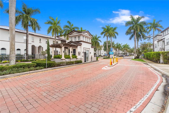 Front view of a residential building with palm trees.