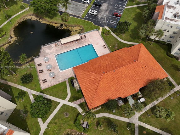 Aerial view of a swimming pool area with surrounding walkways and landscaping.