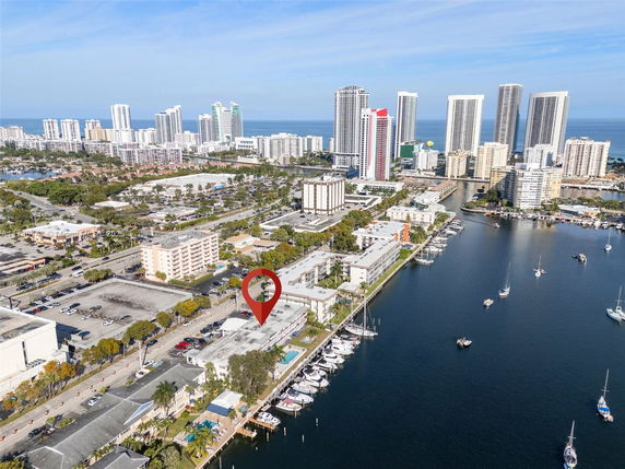 Aerial view of a coastal cityscape with high-rise buildings and a marina.