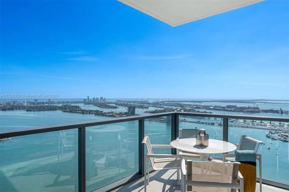 Panoramic view from a balcony showing a wide expanse of water and distant cityscape.