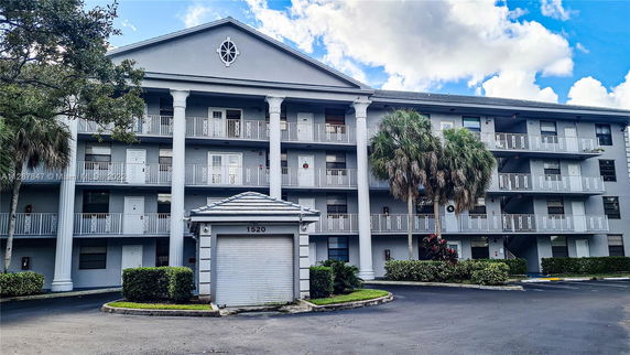 Front view of a multi-story building with balconies and large white columns.