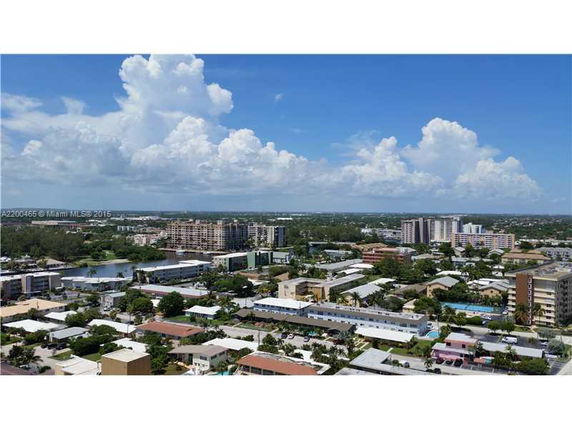 Panoramic view of a suburban area with buildings and cloudy sky in the background.