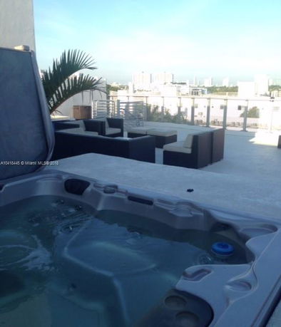 Rooftop area with a hot tub and seating arrangement.