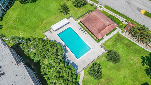 Aerial view of a swimming pool with surrounding greenery and pathways.