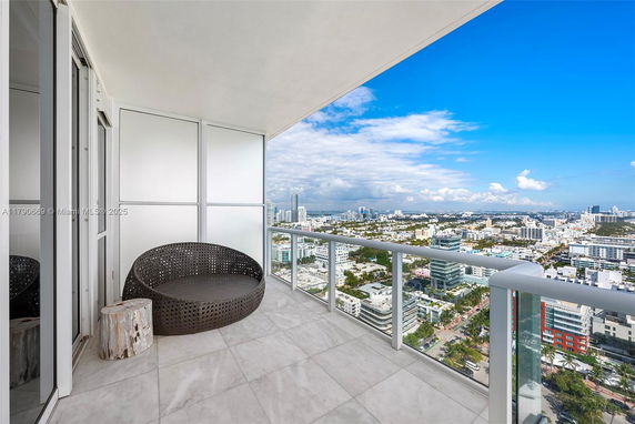 Balcony view overlooking cityscape with modern glass railing.