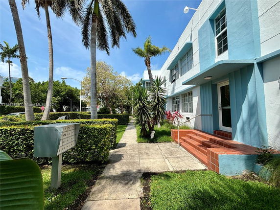 Front view of a two-story building with blue and white exterior and red tile steps.