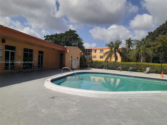 Outdoor area with a swimming pool and adjacent building.